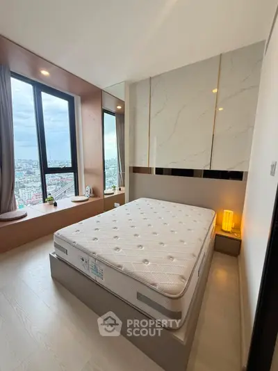 Modern bedroom with large window offering stunning city views and elegant decor.