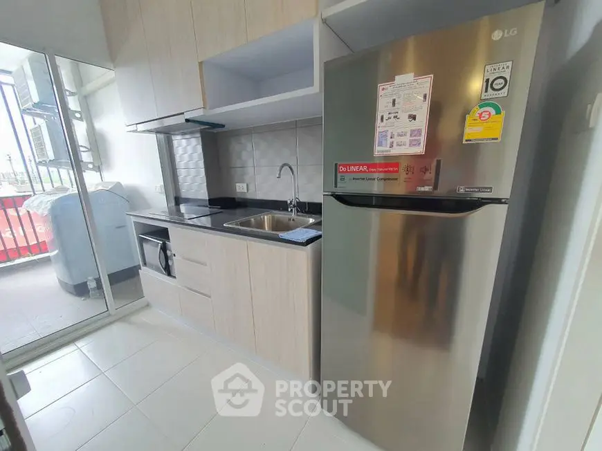 Modern kitchen with stainless steel fridge and balcony view