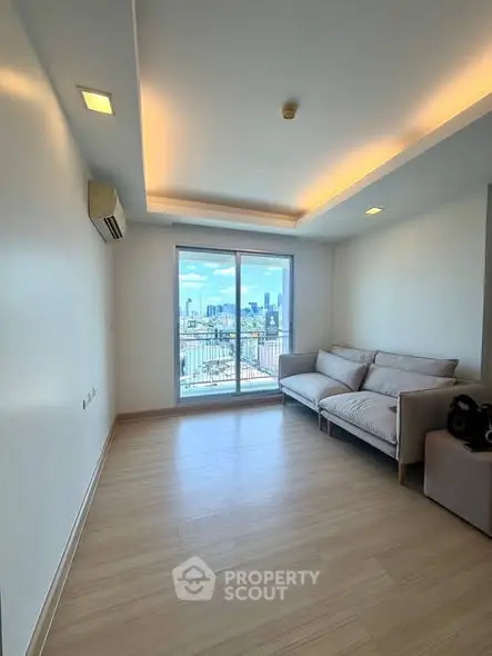 Spacious living room with city view and modern sofa in high-rise apartment.