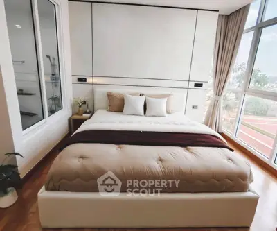 Luxurious bedroom with large windows offering stunning views and elegant decor.