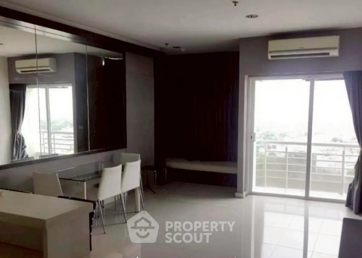 Modern living room with balcony and dining area, featuring sleek design and natural light.