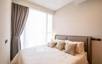 Elegant bedroom with natural light and modern decor in a luxury apartment.