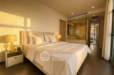 Luxurious bedroom with elegant decor and warm lighting, featuring a comfortable bed and stylish furnishings.