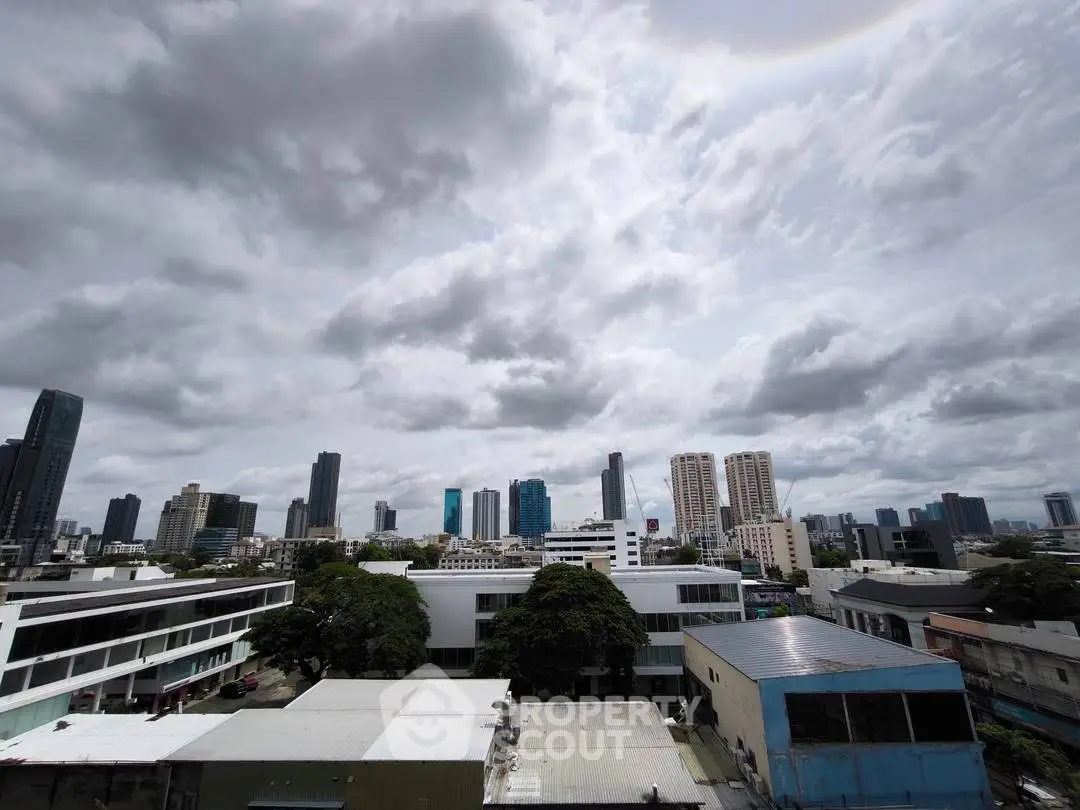 Stunning cityscape view with modern skyscrapers under dramatic cloudy sky.