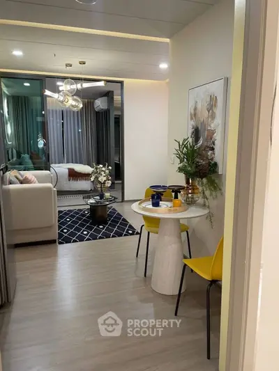 Modern living room with stylish decor and open layout, featuring a cozy seating area and elegant lighting.