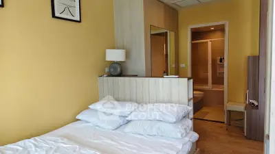 Cozy bedroom with ensuite bathroom and modern decor in a stylish apartment.