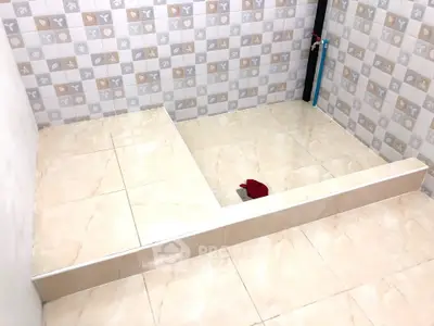 Modern bathroom renovation with stylish tile work and elevated platform.