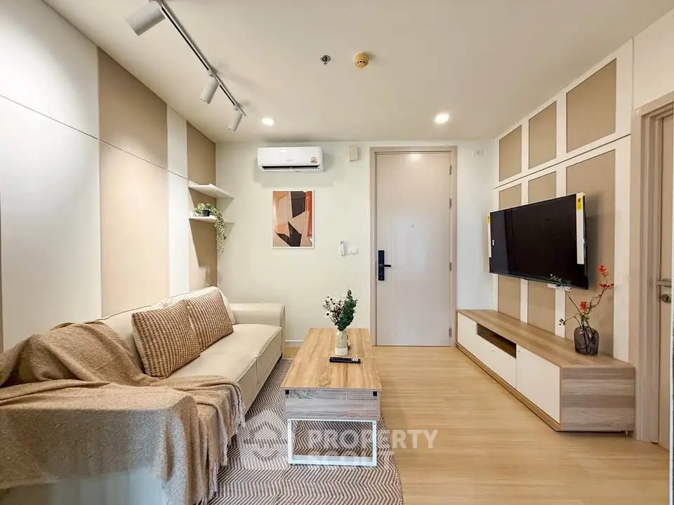 Modern living room with stylish decor, cozy sofa, and wall-mounted TV in a contemporary apartment.
