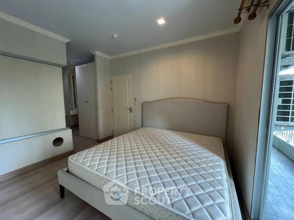 Spacious bedroom with modern design and large window for natural light.