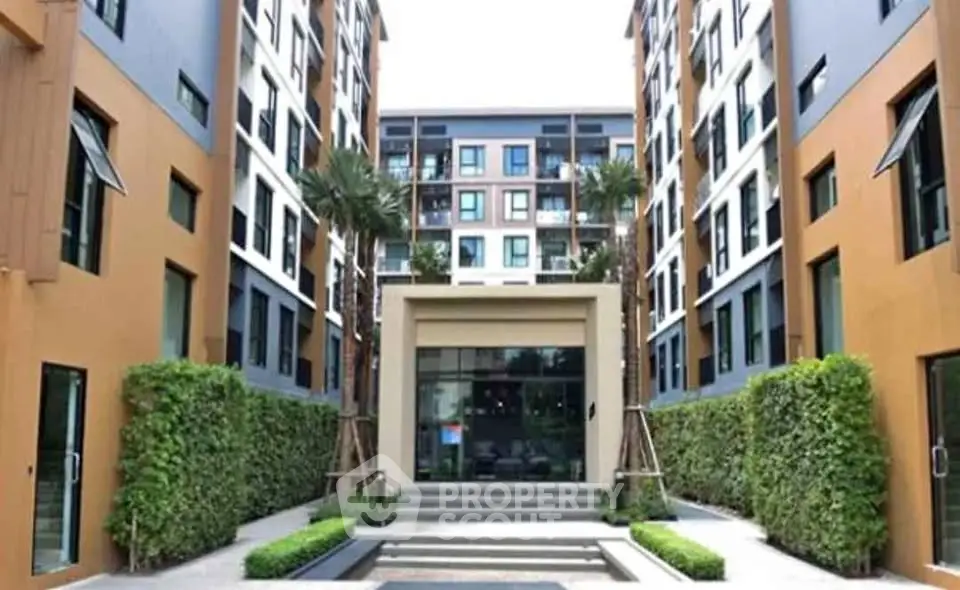 Modern apartment building entrance with lush greenery and stylish architecture