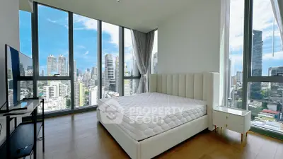 Luxurious bedroom with panoramic city views and modern furnishings in high-rise apartment.