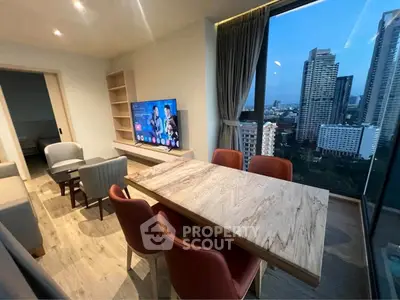Modern living room with city view, stylish furniture, and large windows in high-rise apartment.