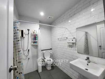 Modern bathroom with sleek white tiles and contemporary fixtures.
