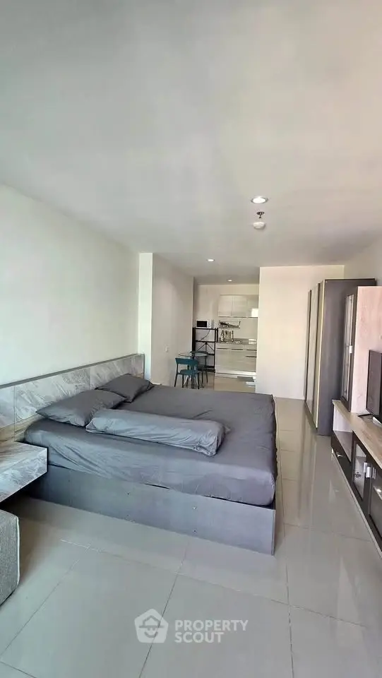 Spacious modern bedroom with sleek design and open layout, featuring a comfortable bed and stylish furnishings.