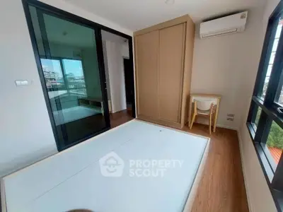 Modern bedroom with large windows, built-in wardrobe, and air conditioning in a bright apartment.