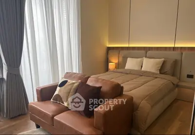 Luxurious bedroom with elegant decor and cozy seating area, featuring floor-to-ceiling windows and soft lighting.