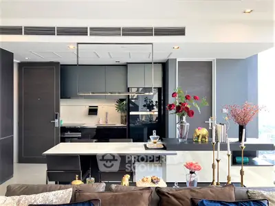 Sleek modern kitchen with integrated appliances and a spacious island, complemented by stylish decor and ample natural light.