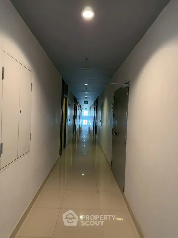 Sleek modern corridor with polished tile flooring and ambient lighting in a contemporary building.