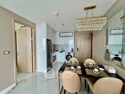 Modern kitchen and dining area with elegant chandelier and sleek appliances