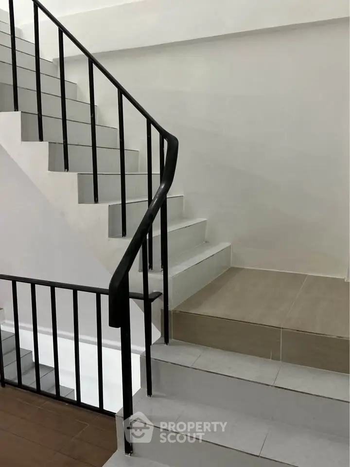 Modern staircase with sleek black railing in a contemporary building