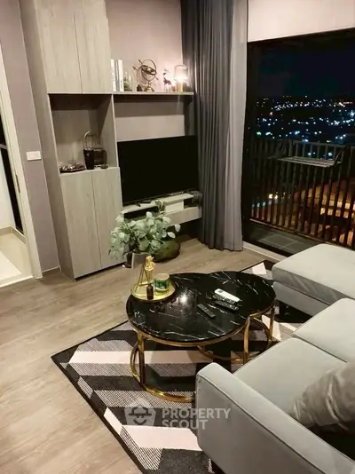 Stylish living room with modern decor and city view from balcony at night.