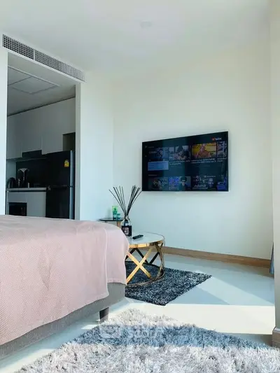 Modern living room with cozy decor and wall-mounted TV in a stylish apartment.