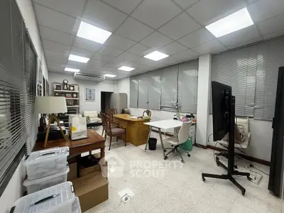 Spacious office space with modern lighting and ample natural light, ideal for productivity and collaboration.