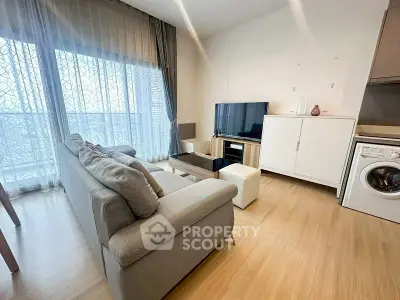 Modern living room with cozy sofa, TV, and washing machine in stylish apartment.