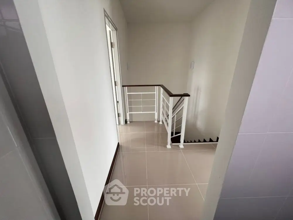 Modern minimalist hallway with sleek staircase and neutral tones