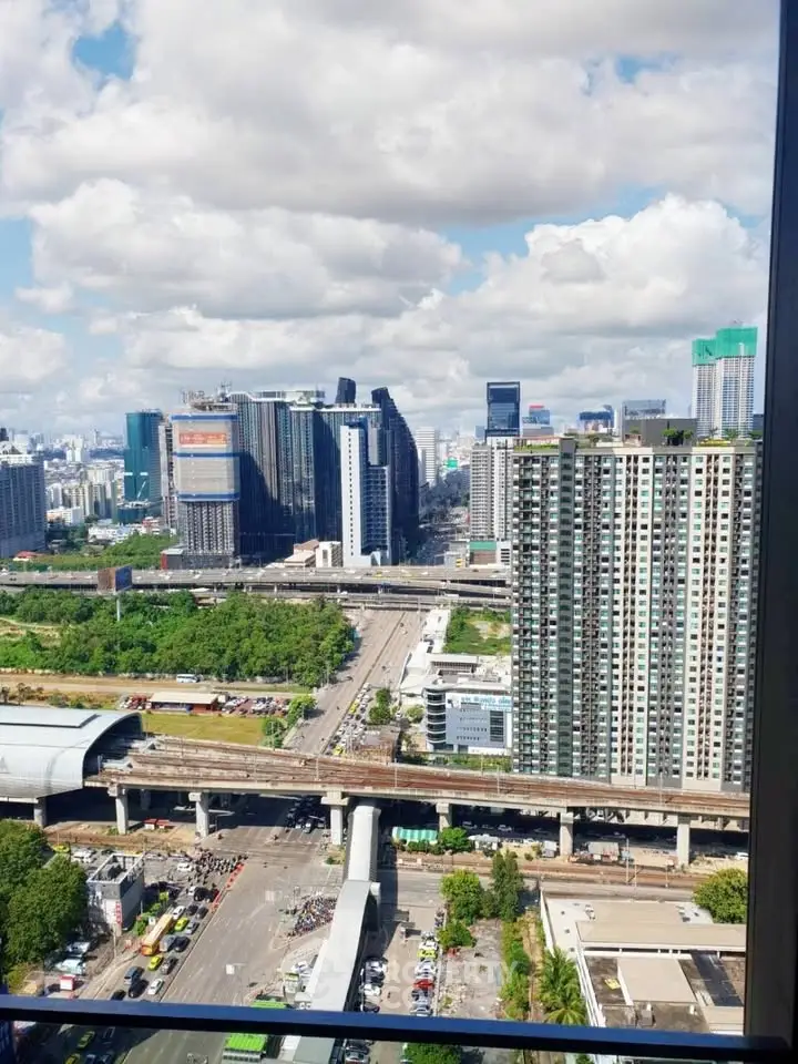 Stunning cityscape view from high-rise apartment with lush greenery and modern architecture.