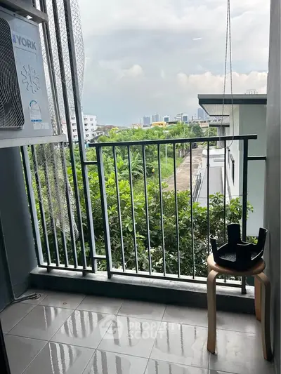 Charming balcony with lush greenery and cityscape view, perfect for relaxation and enjoying the outdoors.
