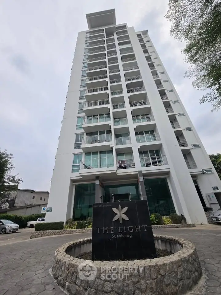 Modern high-rise building with sleek design and spacious balconies in urban setting.