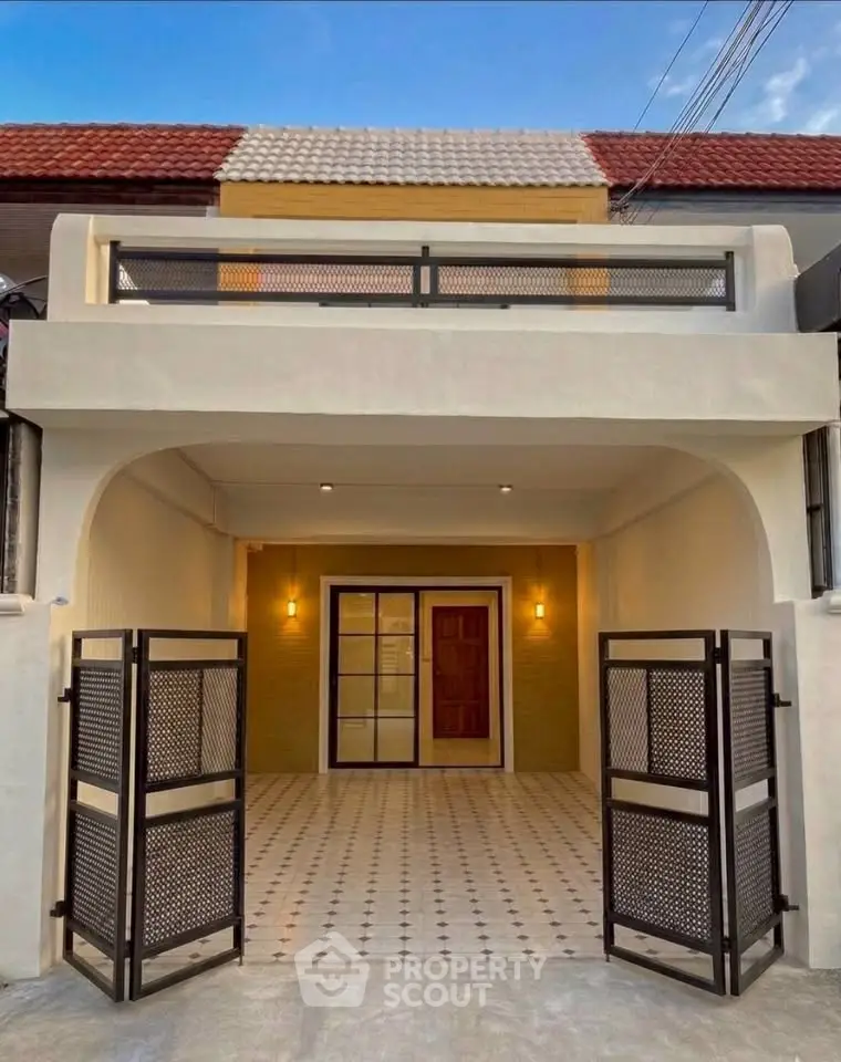 Charming two-story house with modern facade and gated entrance, perfect for family living.