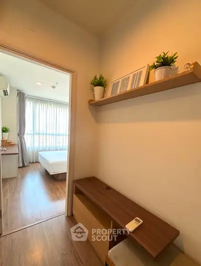 Cozy bedroom entrance with wooden flooring and decorative shelf