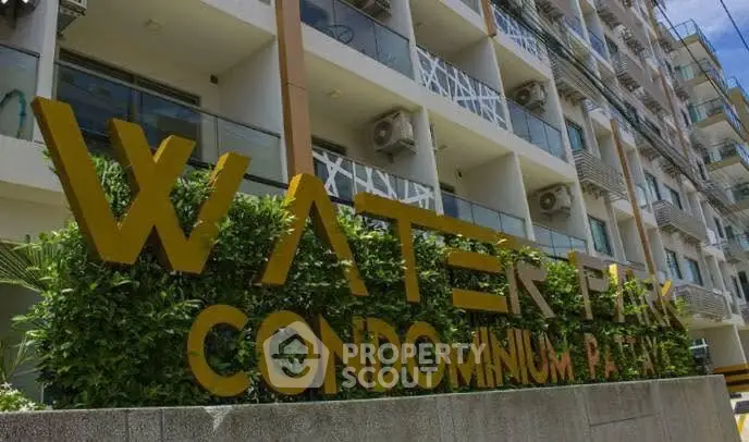 Modern condominium building exterior with prominent signage and balconies.