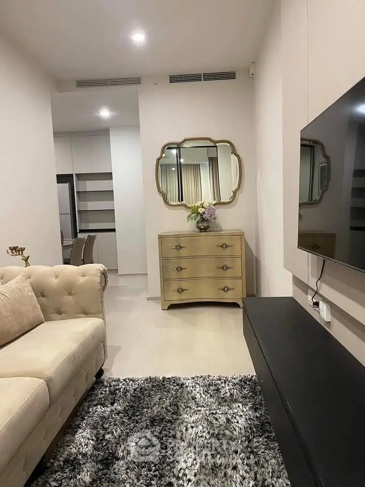 Elegant living room with plush sofa, stylish mirror, and modern decor in a cozy apartment.