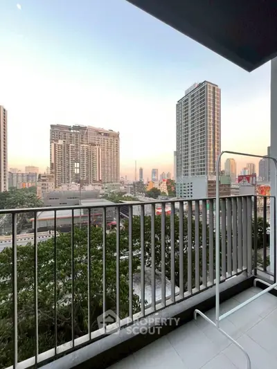 Spacious balcony with stunning city skyline view at sunset.