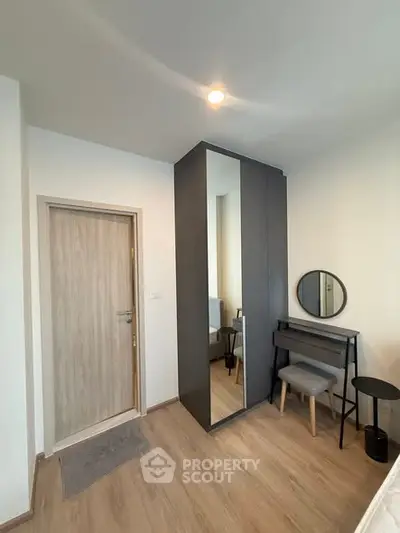 Modern bedroom with sleek wardrobe and stylish vanity area, perfect for urban living.