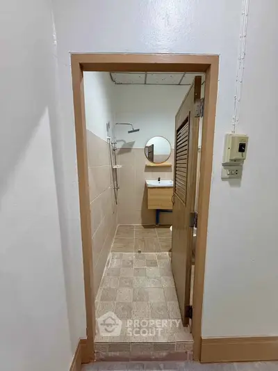 Compact bathroom with shower and sink in a minimalist design