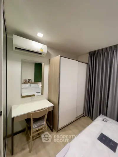 Modern bedroom with air conditioning, wardrobe, and study desk in a cozy apartment.