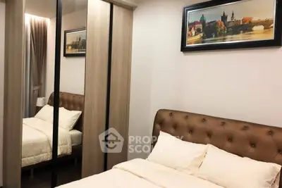Cozy bedroom with elegant decor and mirrored wardrobe in modern apartment.