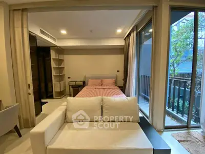 Modern bedroom with large windows and balcony access in a stylish apartment.