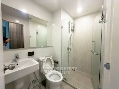 Modern bathroom with glass shower and sleek fixtures in a contemporary apartment.