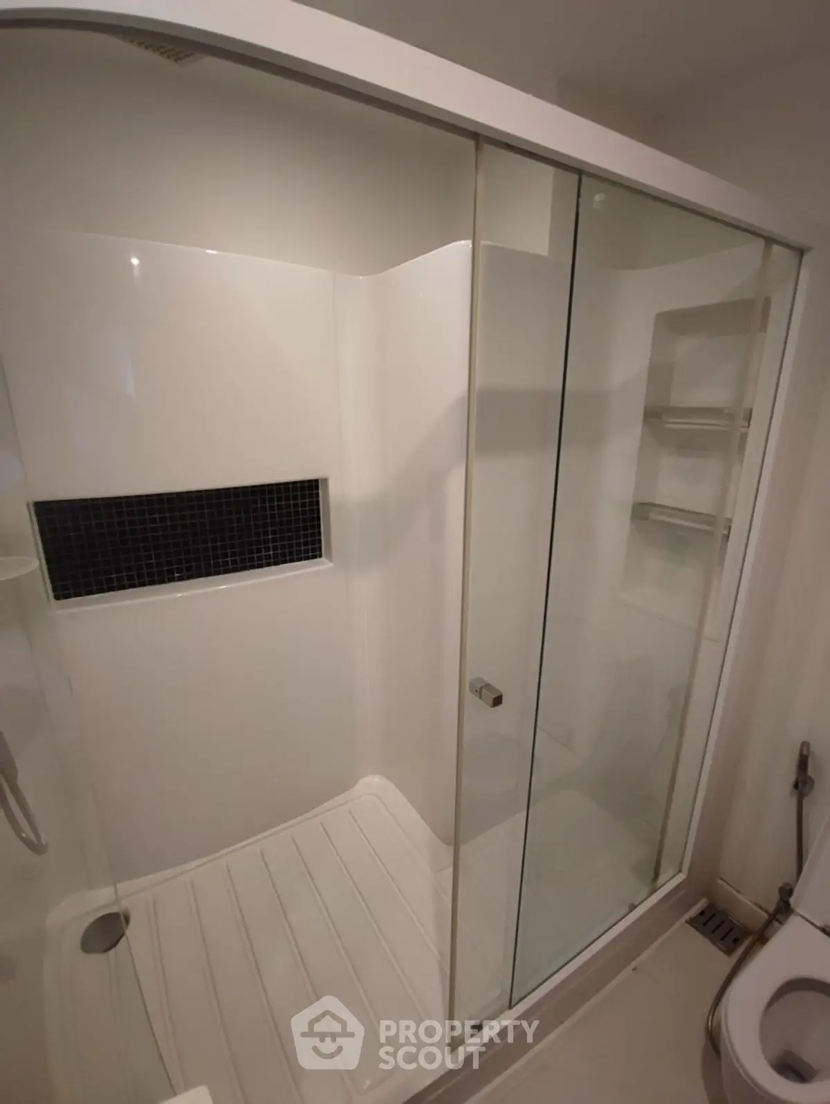 Modern bathroom with sleek glass shower enclosure and white tiles.