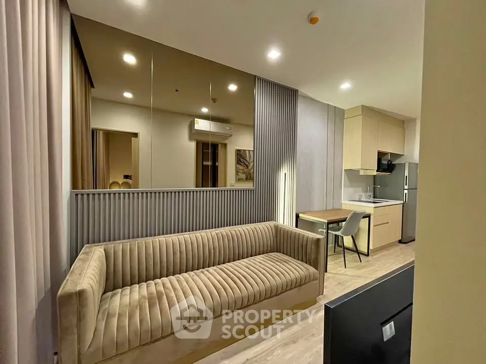 Modern living room with stylish sofa and open kitchen layout in a chic apartment.