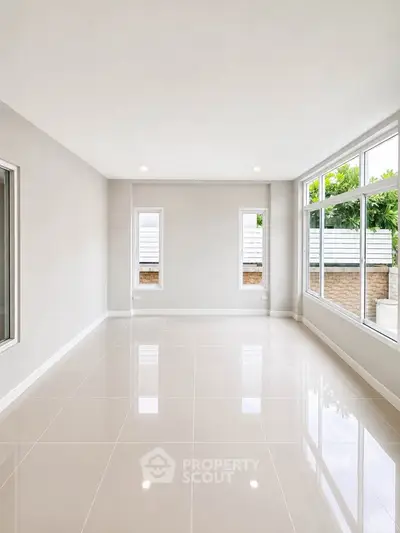 Spacious empty room with large windows and glossy tiled floor, perfect for customization.