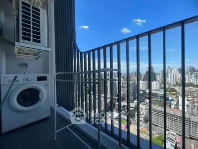 Stunning city view from a high-rise balcony with washing machine and air conditioning unit.