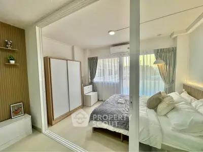 Modern bedroom with sliding glass doors, cozy bed, and ample natural light.