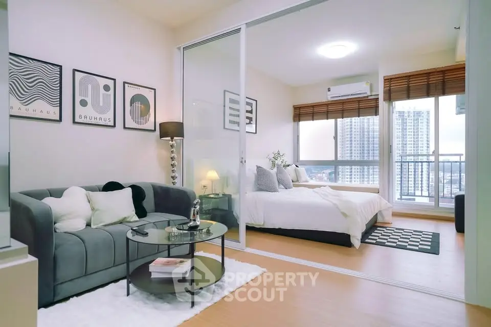 Modern open-plan living room and bedroom with city view in high-rise apartment