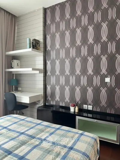 Modern bedroom with stylish wallpaper and cozy study nook, perfect for urban living.